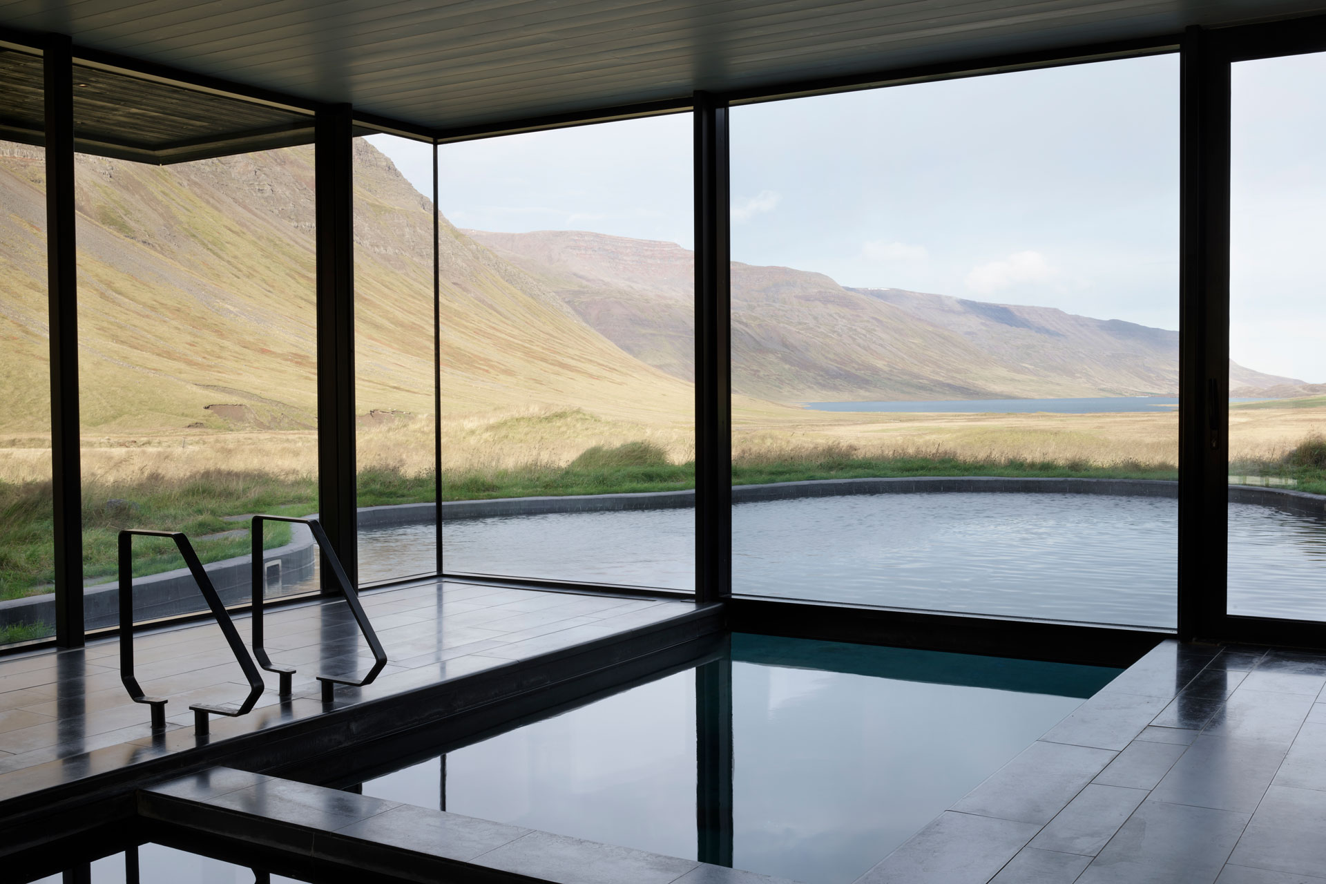 A swimming pool overlooks a landscape deplar farm scandinavia