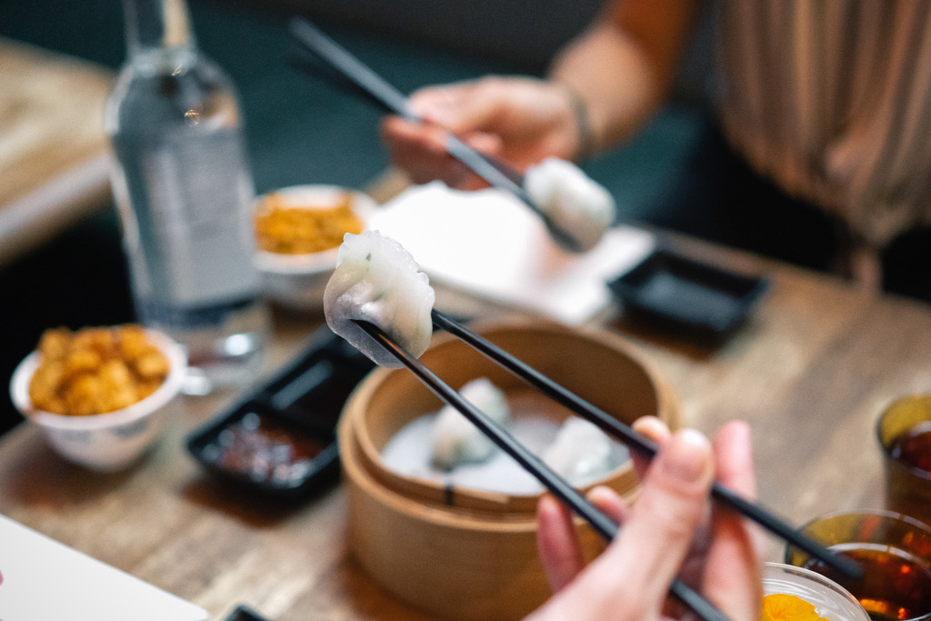 chopsticks with dim sum on end 