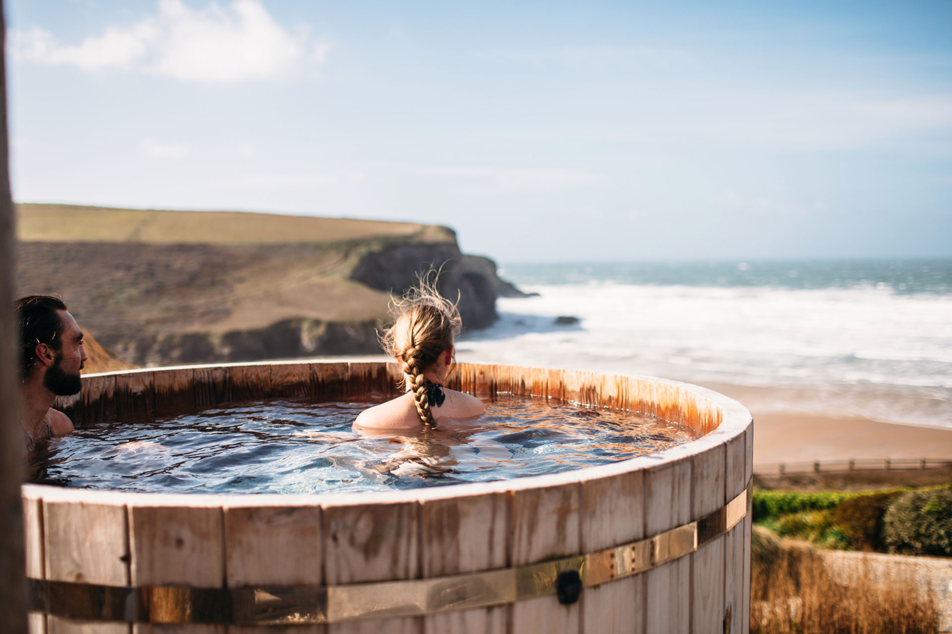 A woman looks out from a hot tub onto a cornish coast The Scarlet Hotel