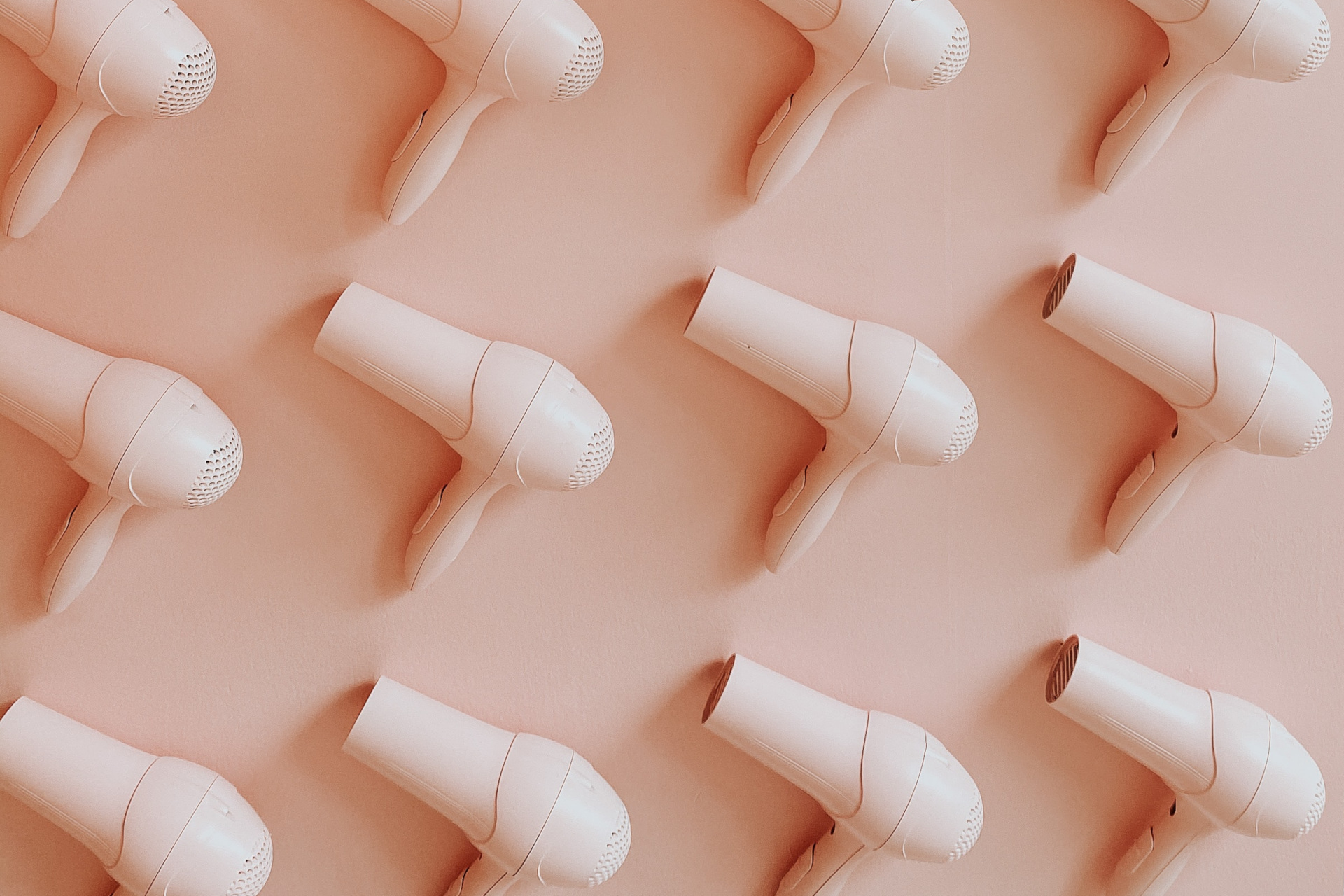Pink hairdryers on pink background