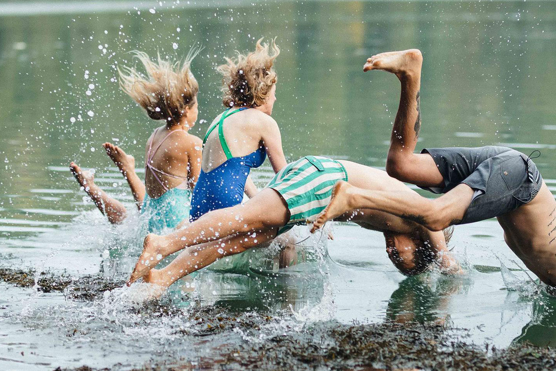 a group of people dive into a lake wild swimming thera sea cornwall