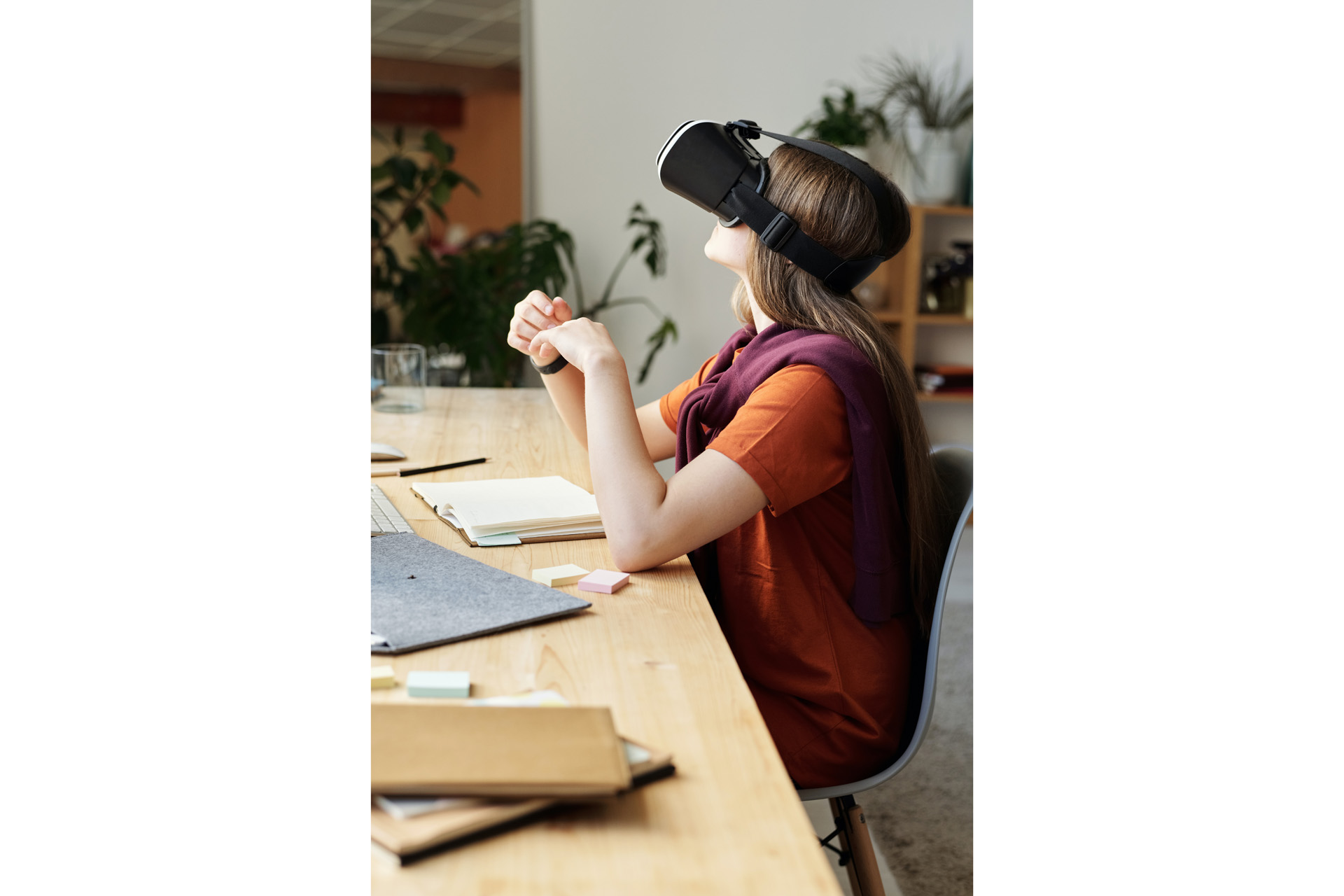 a woman sat at a desk with a vr headseat