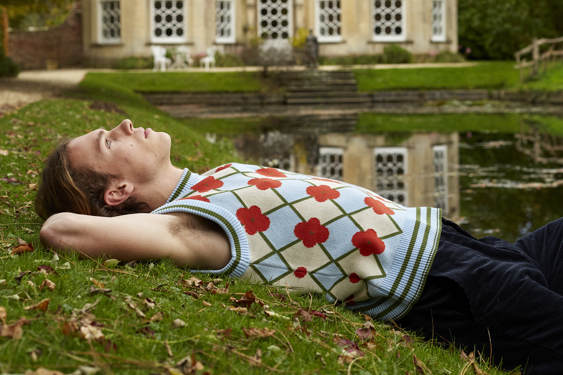 Model reclining on grass with arms up
