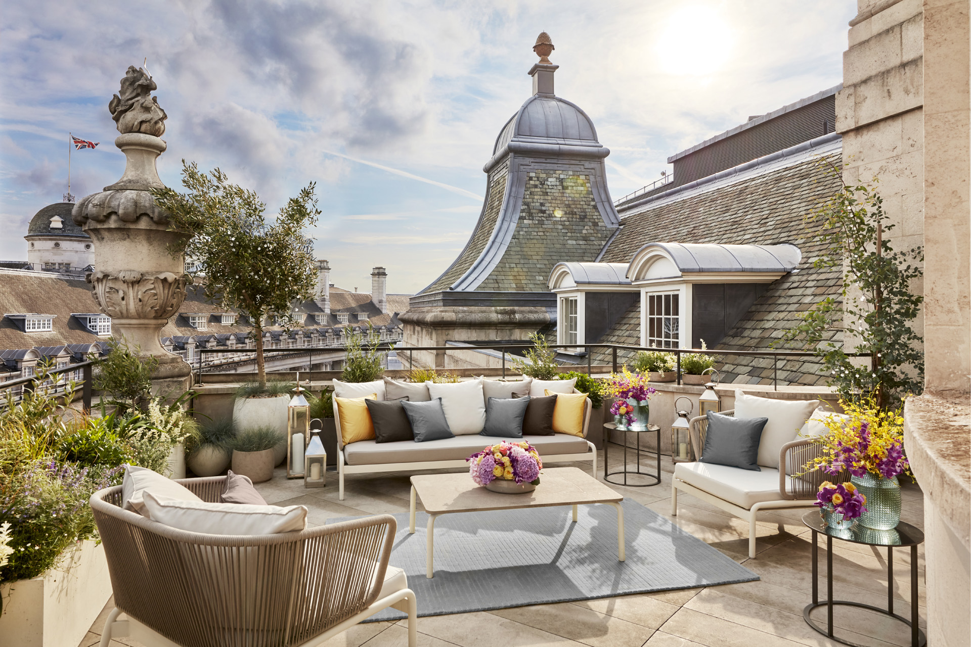 the Hotel Cafe Royal Dome Penthouse terrace during summer, with sofas around a table and London rooftops in the background