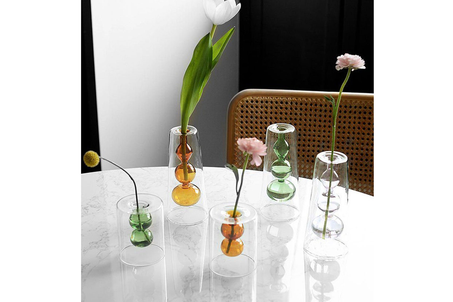 A selection of glass hydroponic vases with flower stems