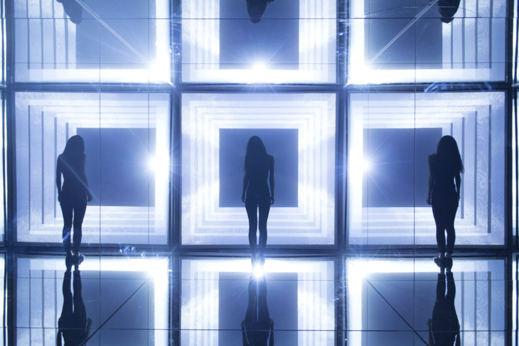 Mirrored room with people stood inside