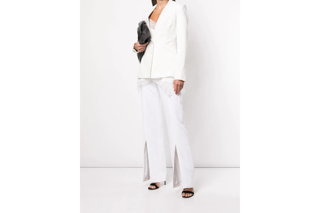 Model in white tailored jacket and front-slit trousers