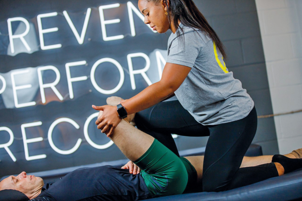 Woman stretching out a man's leg
