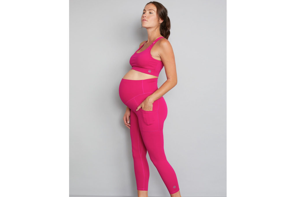 Pregnant model in pink leggings and sports bra
