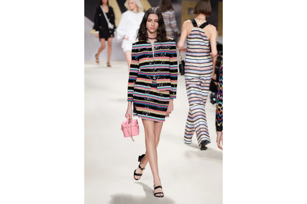 Model on catwalk in Chanel sequin stripe miniskirt suit