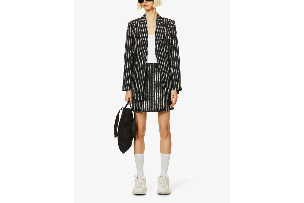 Model in black woven blazer and skirt