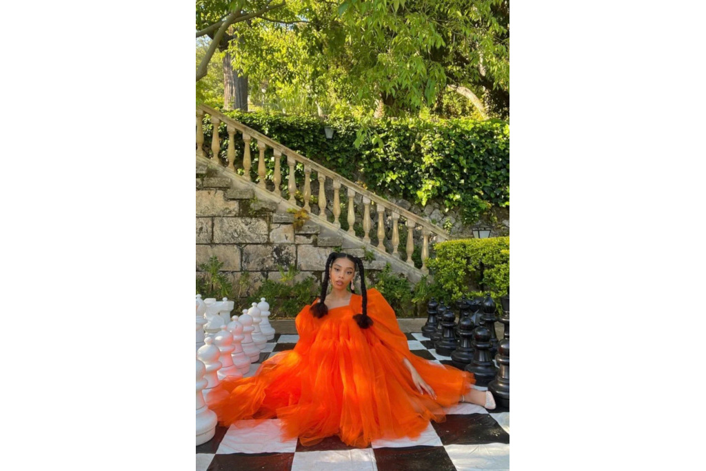 Woman sat outdoors in orange tulle dress