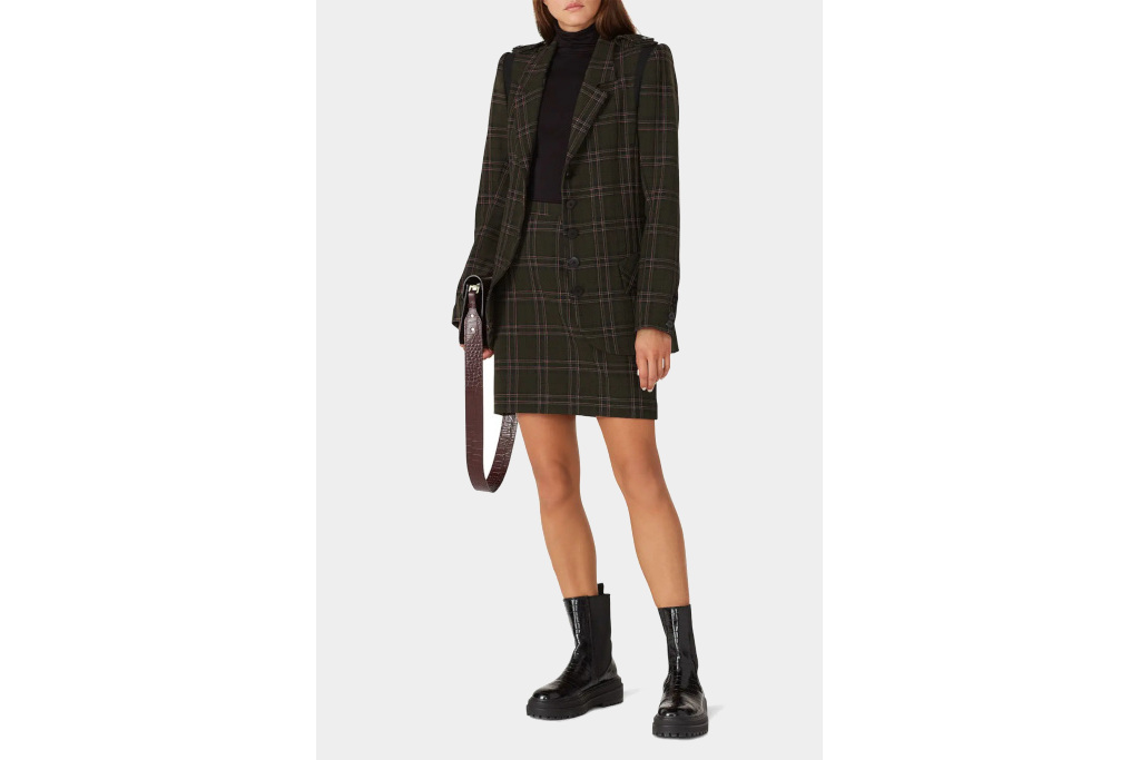 Model in plaid jacket and skirt on plain background