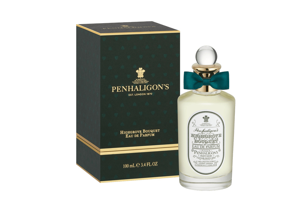 Bottle of perfume next to dark green box