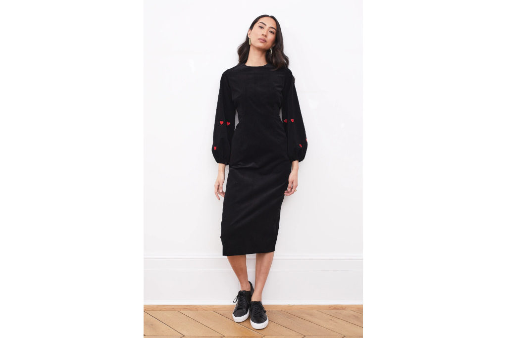 Model in Black Up-Cycled Organic Cord Dress With Red Hearts