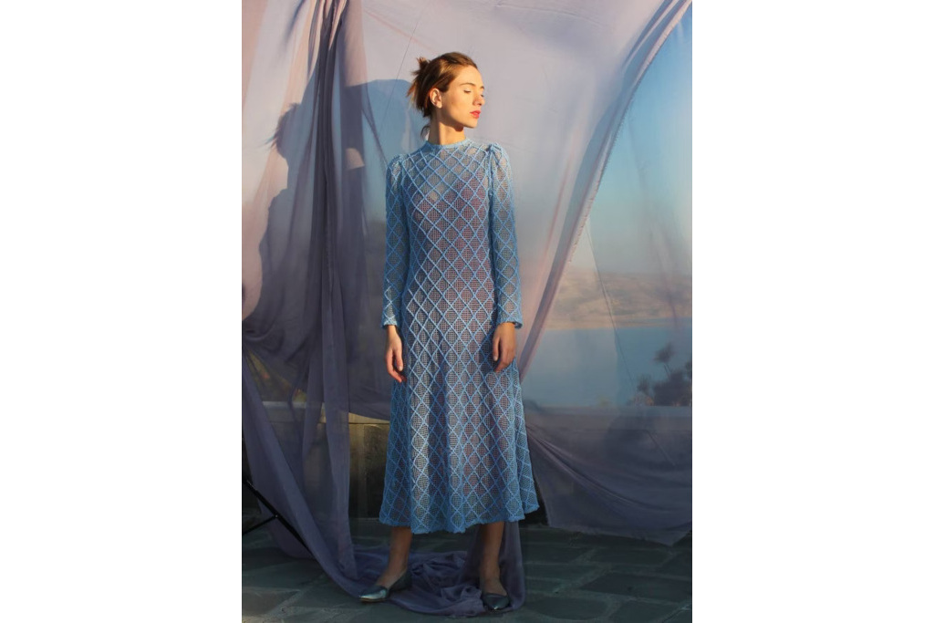 Model in blue net dress on light purple background