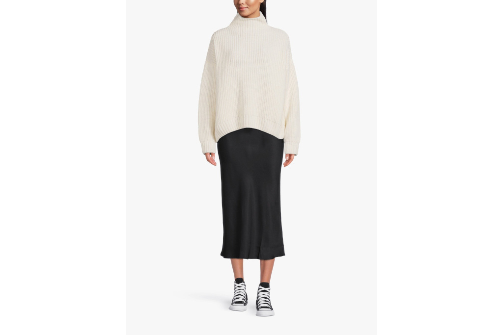Woman in white jumper and black skirt