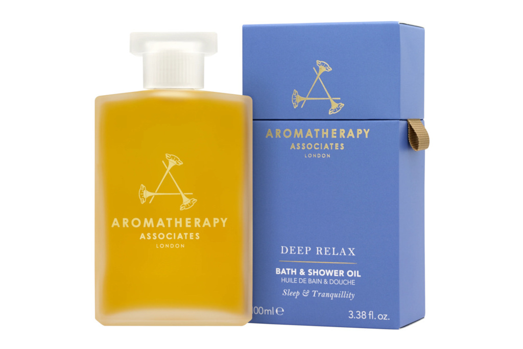 Clear bottle of bath oil next to blue box