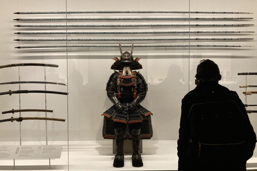 Someone viewing a samurai armour in a display case