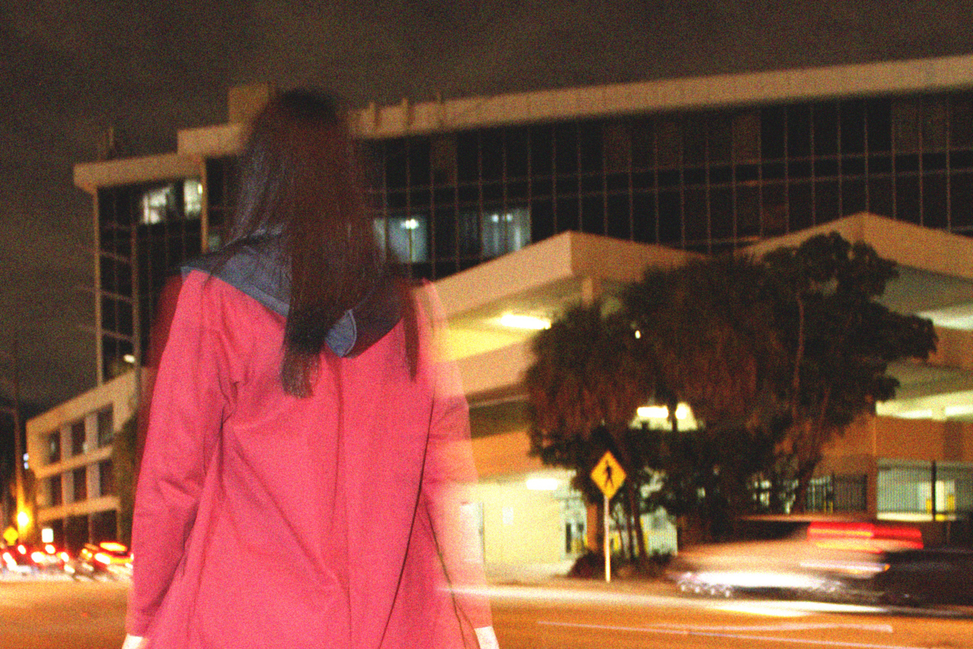 Model in red coat walking away from the camera