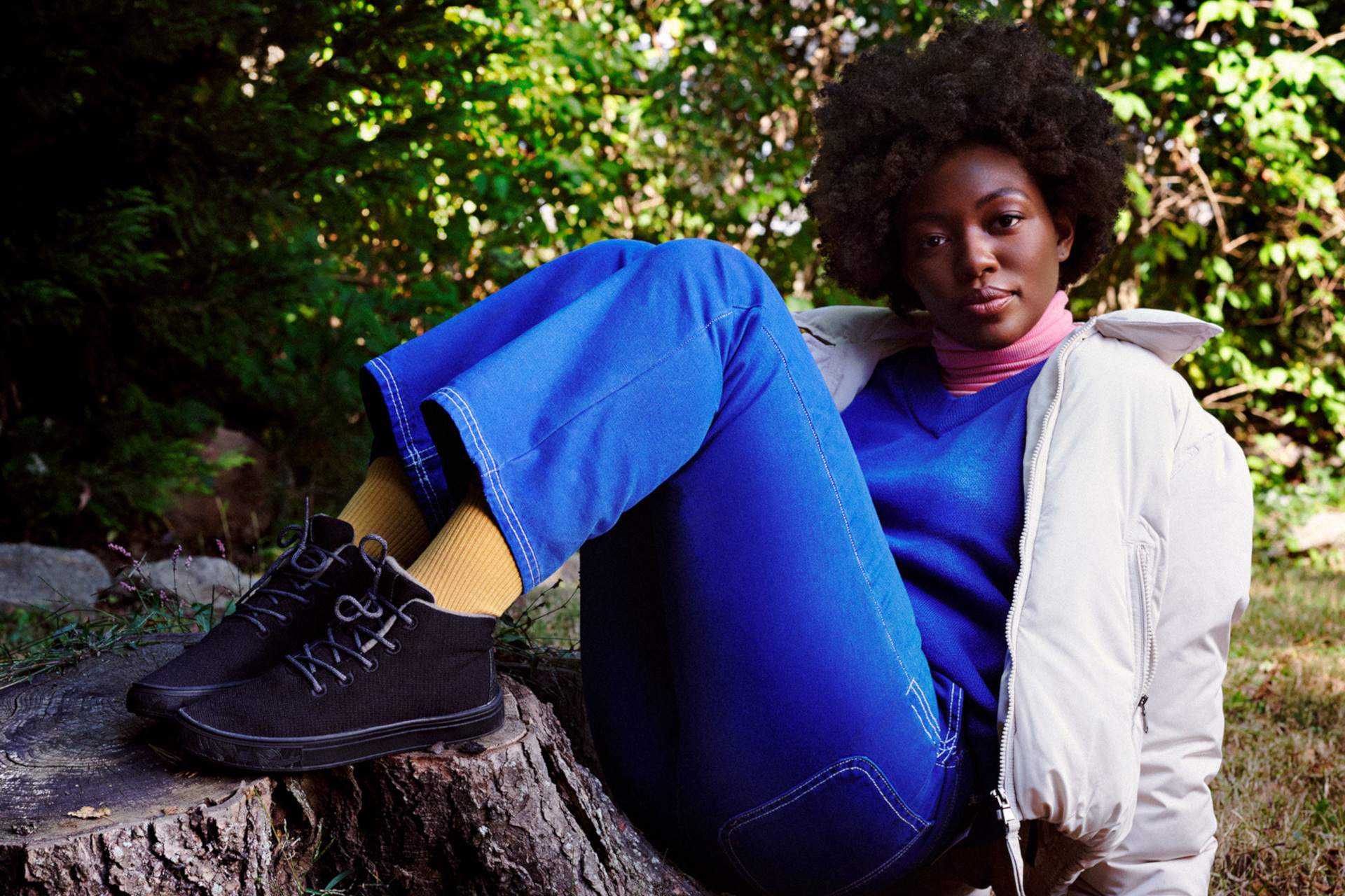 Model with feet up on tree stump