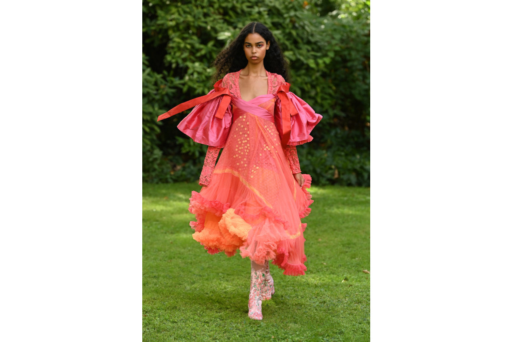 Model in peach pink dress and boots in a park
