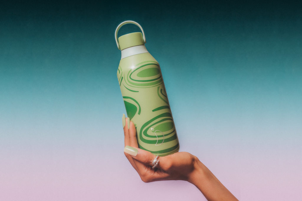 Hand holding green patterned bottle