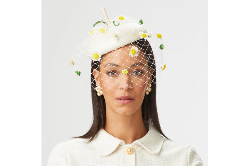 Woman in white beret with daisies made by British milliner Lock & Co.