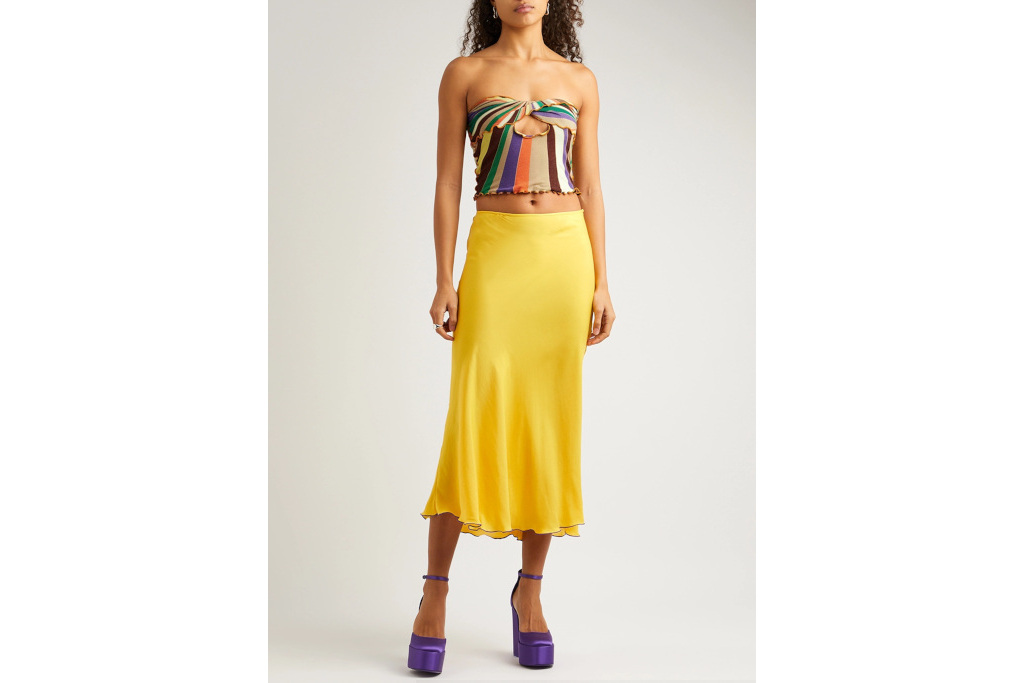 Woman in colourful stripe top and yellow skirt