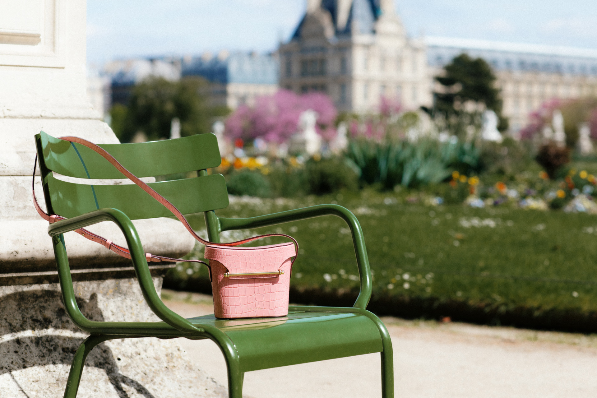 Pink bag on green chair overlooking a park