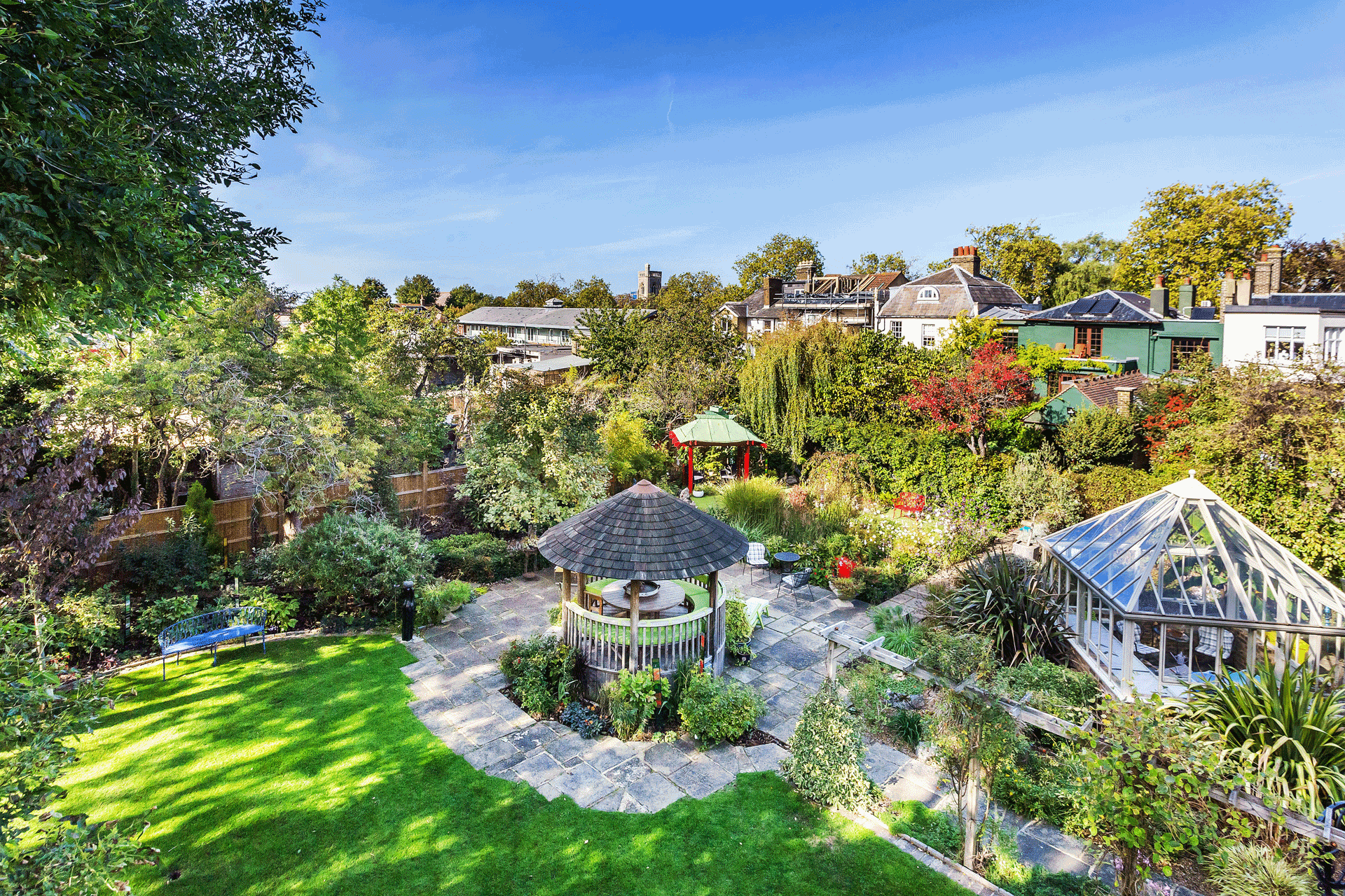 Back garden with gazebo, greenhouse and plants.