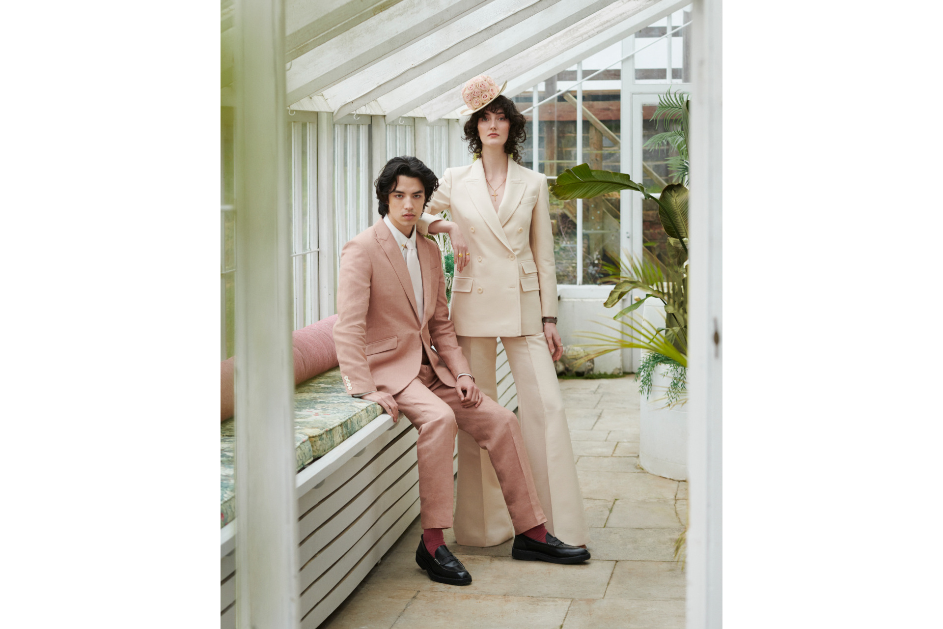 Man and woman in light pink suits in conservatory