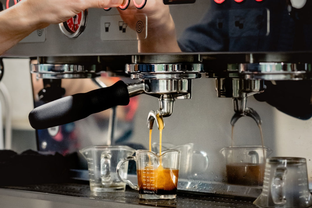 a close up of an espresso being made by a luxury coffee machine by a barista