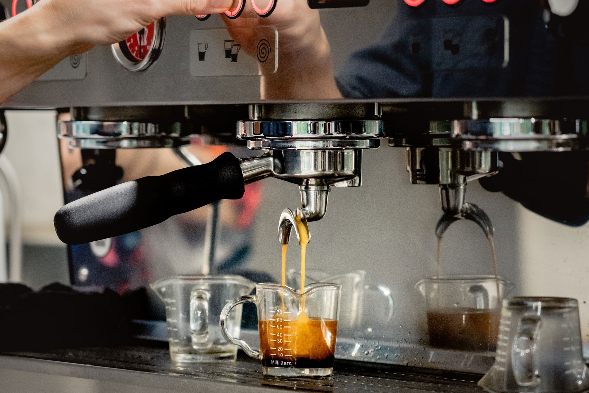 a close up of an espresso being made by a luxury coffee machine by a barista