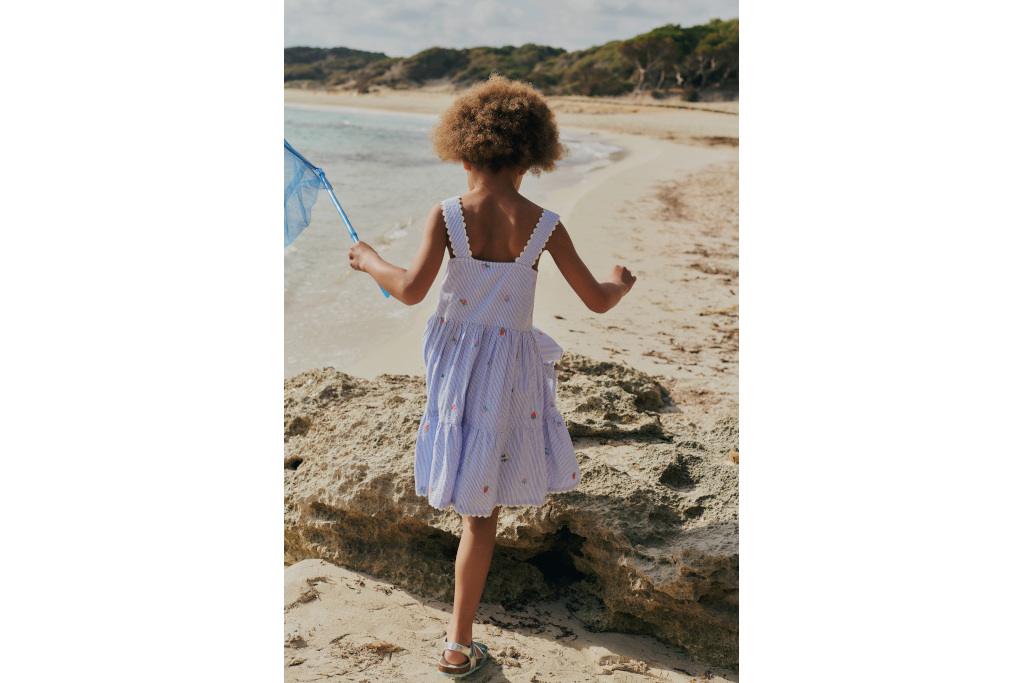 Young girl in a summer dress at the beach