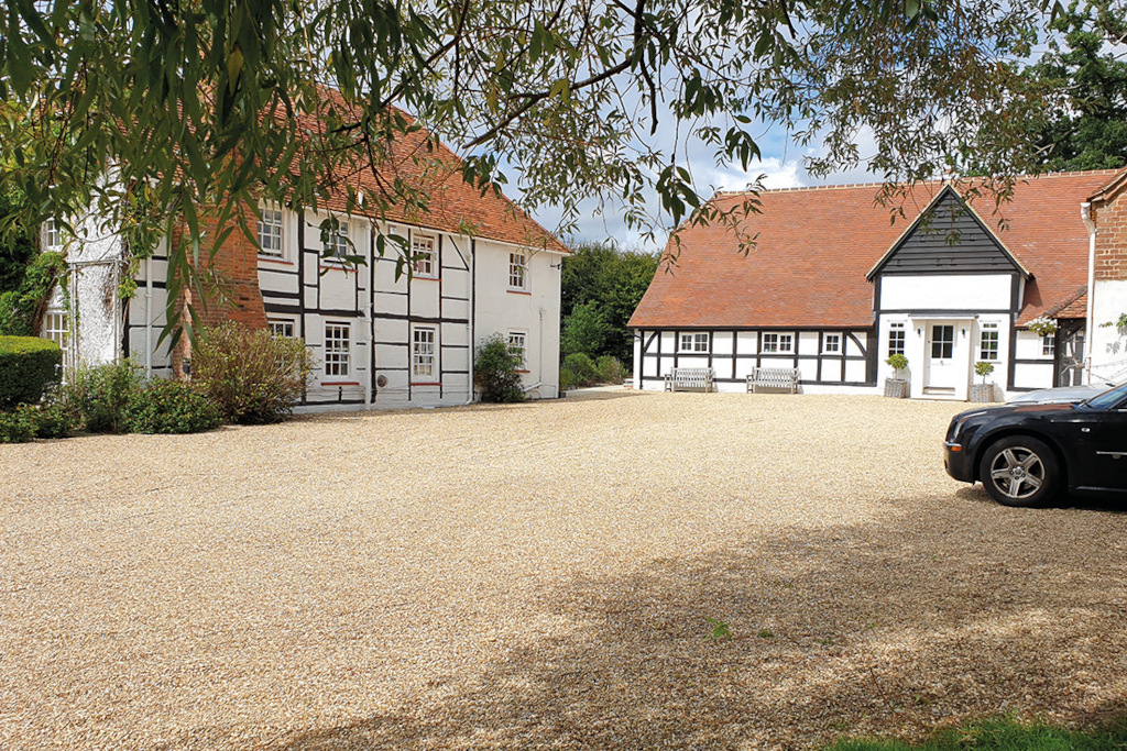 white house with black beams and terracotta roof with courtyard