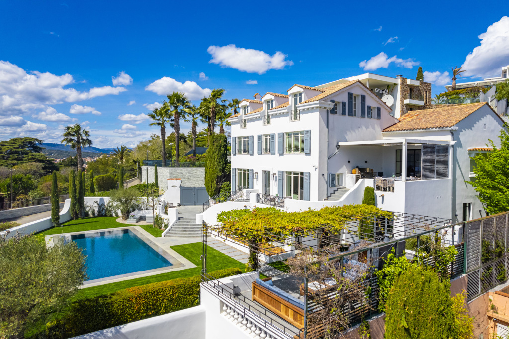 side view of white french villa and pool