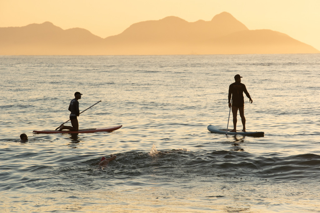 two people paddle boarding in evening sun