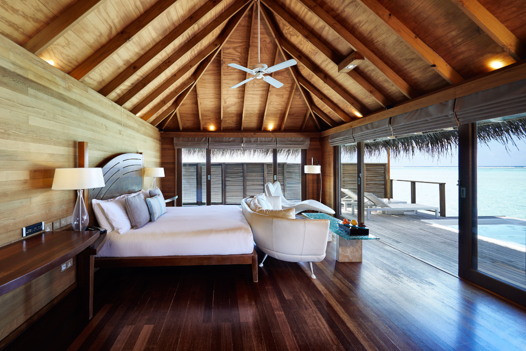 maldives bedroom with wooden floor and wooden vaulted beamed ceiling with balcony