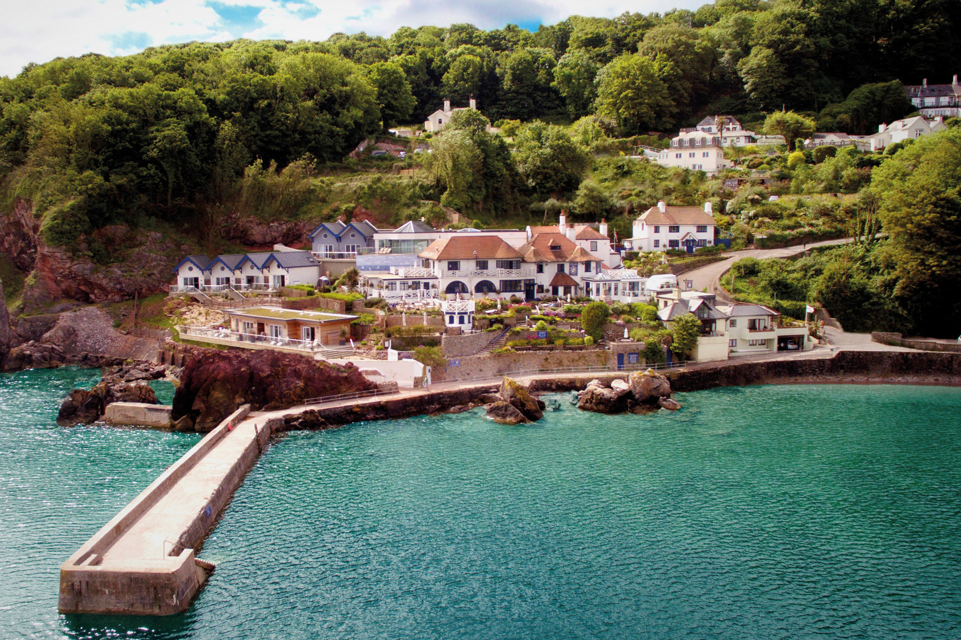 Exterior shot of Cary Arms & Spa and the sea beside it