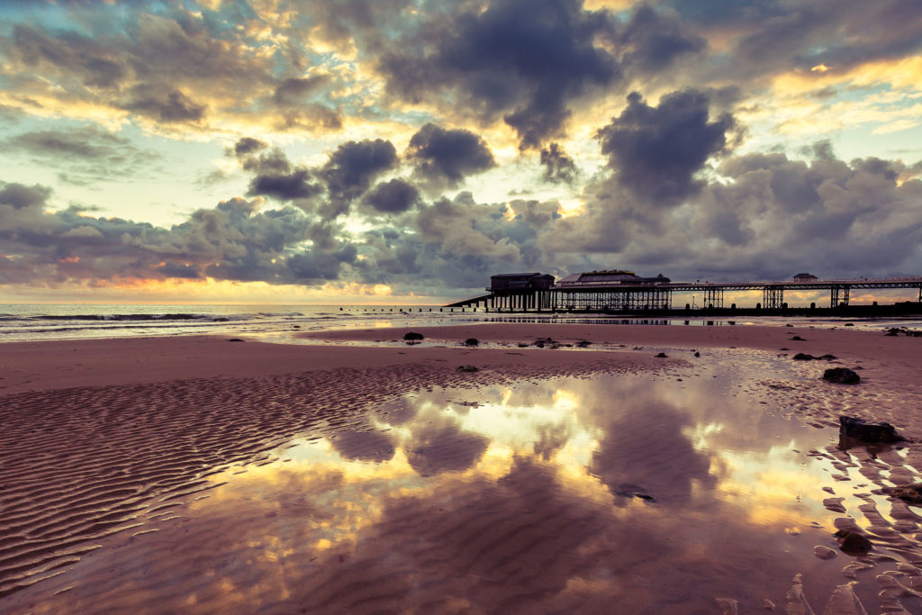 Tides out and the sun rises on Cromer beach, Norfolk, uk