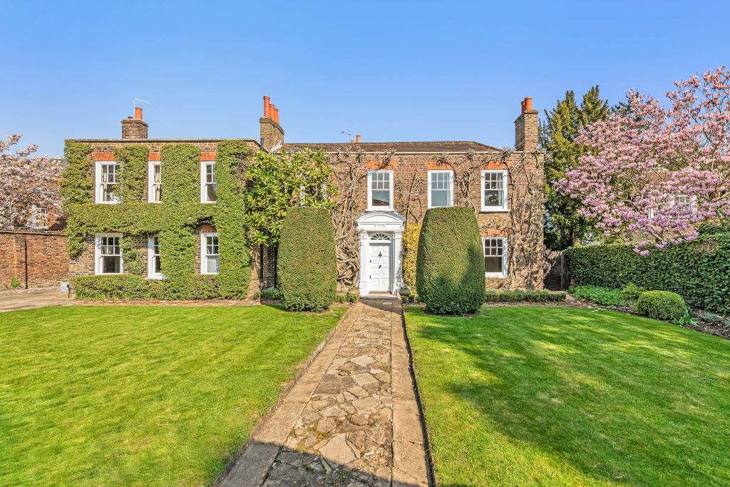 wisteria clad red brick property with garden Harrington Lodge