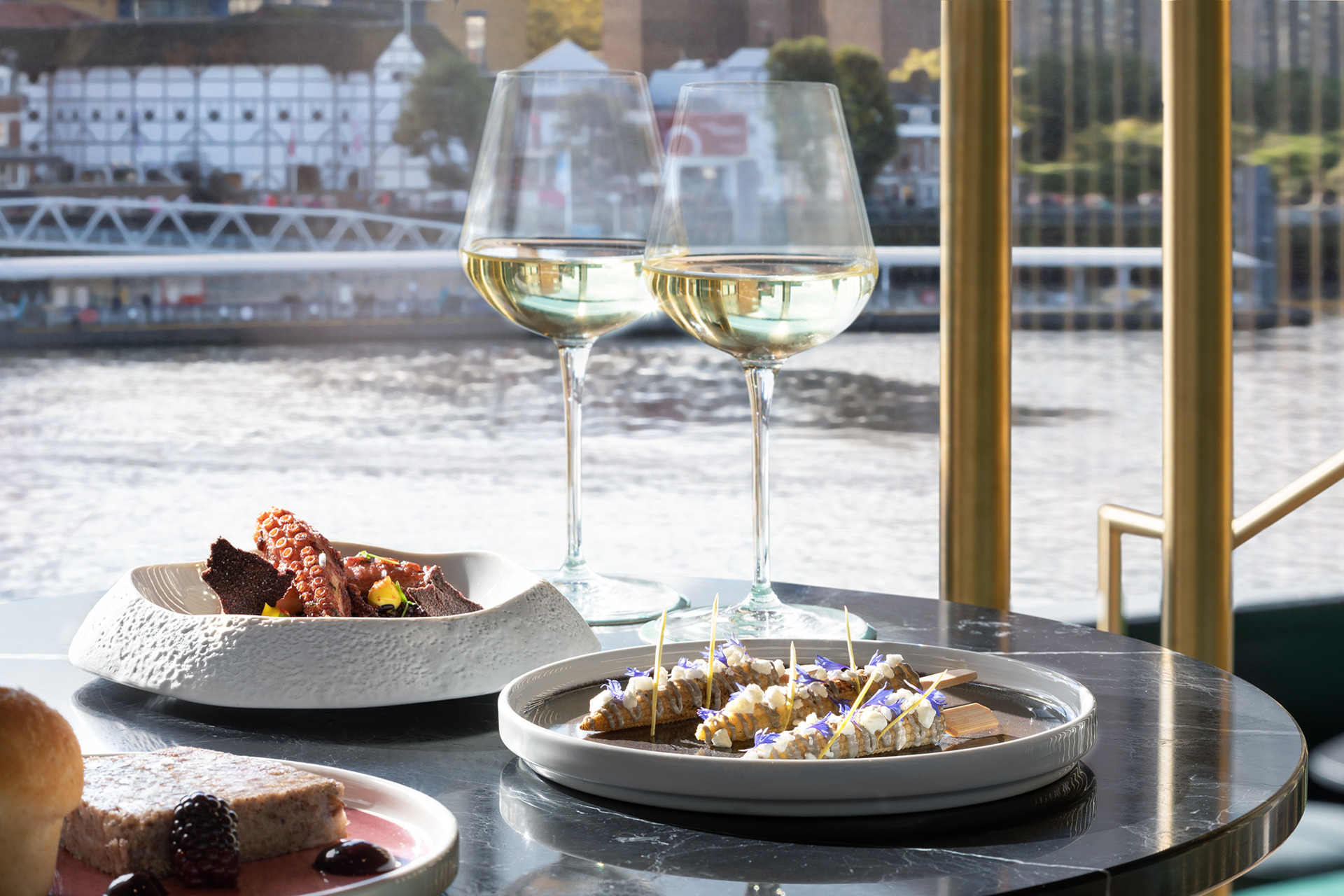Table overlooking the Thames, with wine and plates of food