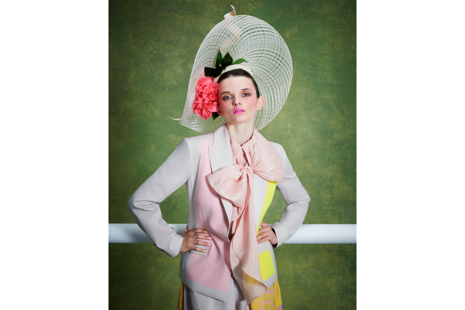 Woman in pastel suit and large hat with flowers