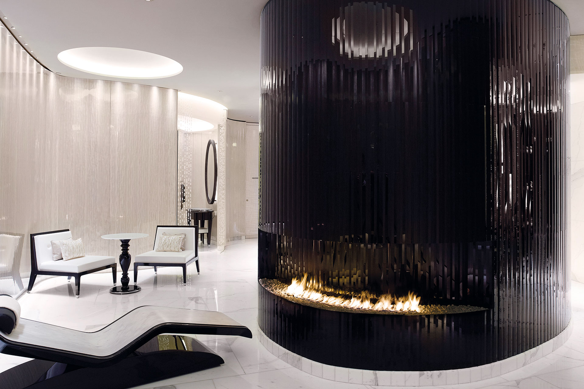 A big fireplace, two white loungers,