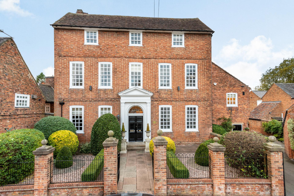 double fronted red brick georgian house with white pane windows