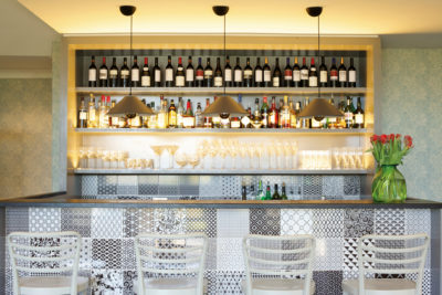 Tiled bar with wall of bottles behind it