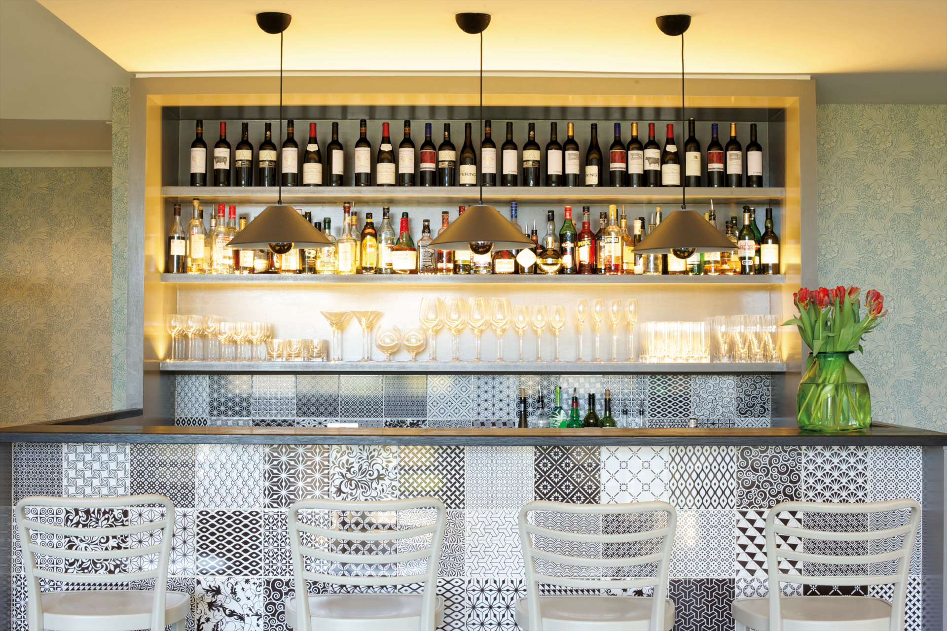 Tiled bar with wall of bottles behind it