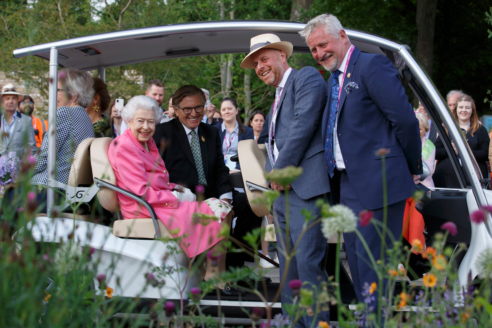 Britain's Queen Elizabeth smiles with garden designer Joe Swift and Mark Gregoy, an RHS ambassador, at the 'BBC Studios Our Green Planet and RHS Bee Garden', as she tours the garden in a buggy with RHS president Keith Weed during a royal visit to RHS Chelsea Flower Show 2022, Monday May 23, 2022