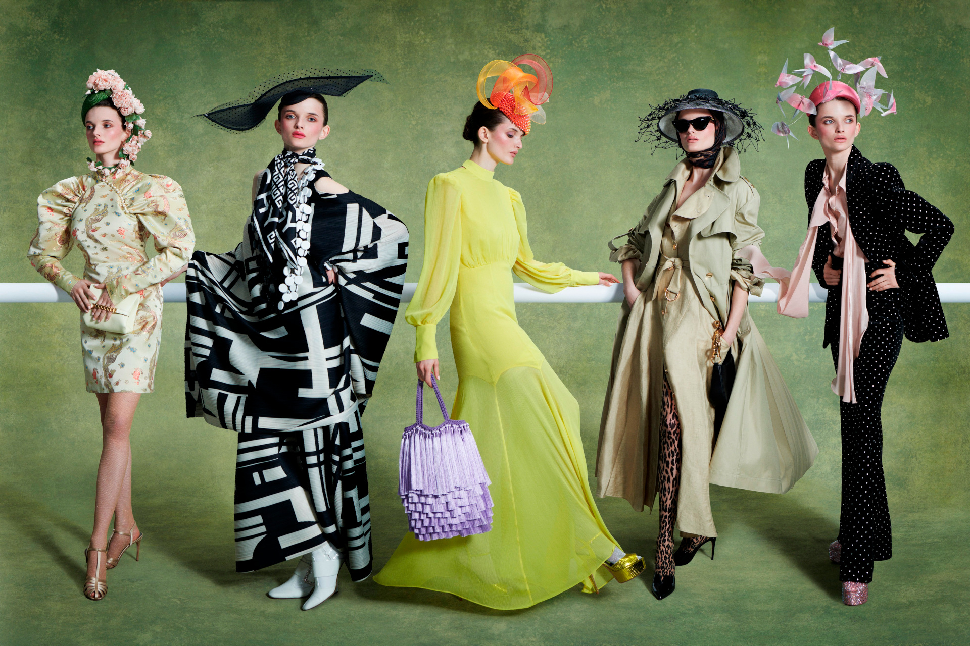 Woman lined up in colourful outfits and grand hats